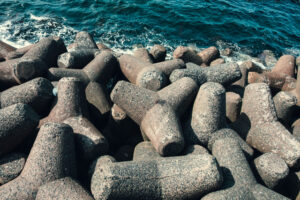 青い海 を 背景 に 無数 に 積み重なる 消波ブロック